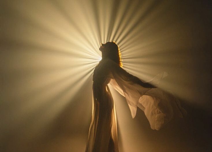 femme en robe blanche dans les rayons du soleil