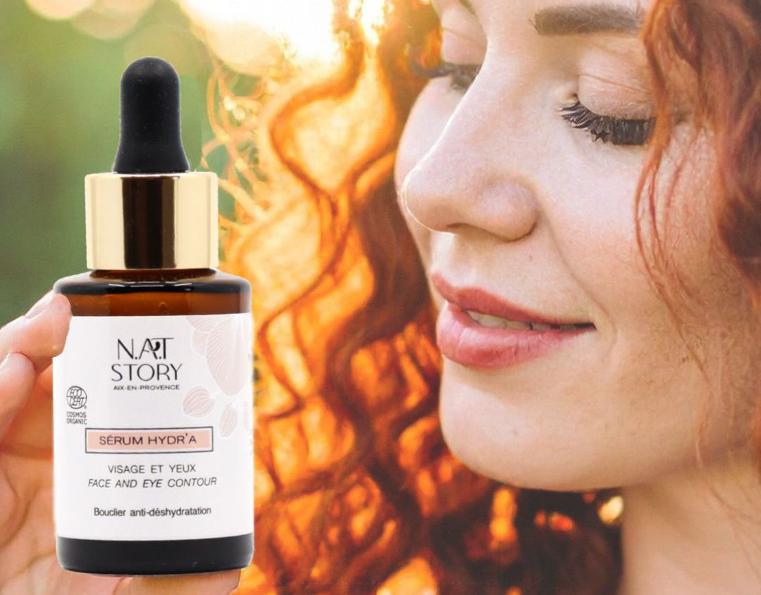 Femme rousse tenant un flacon de sérum devant son visage