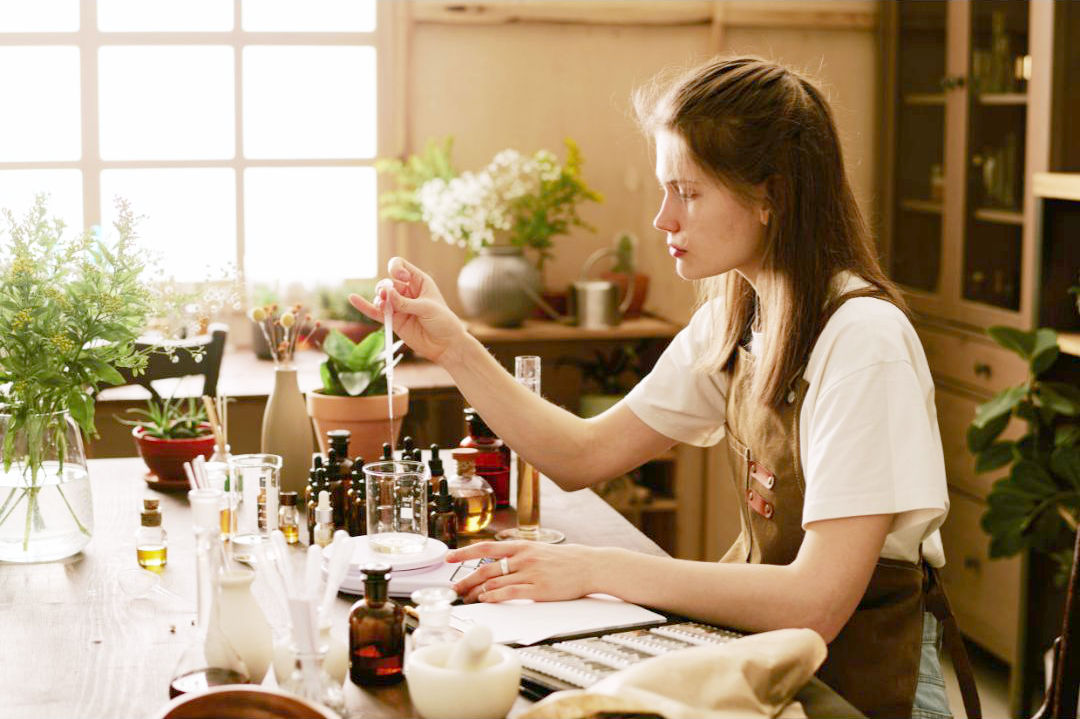 femme avec flacons composant un parfum